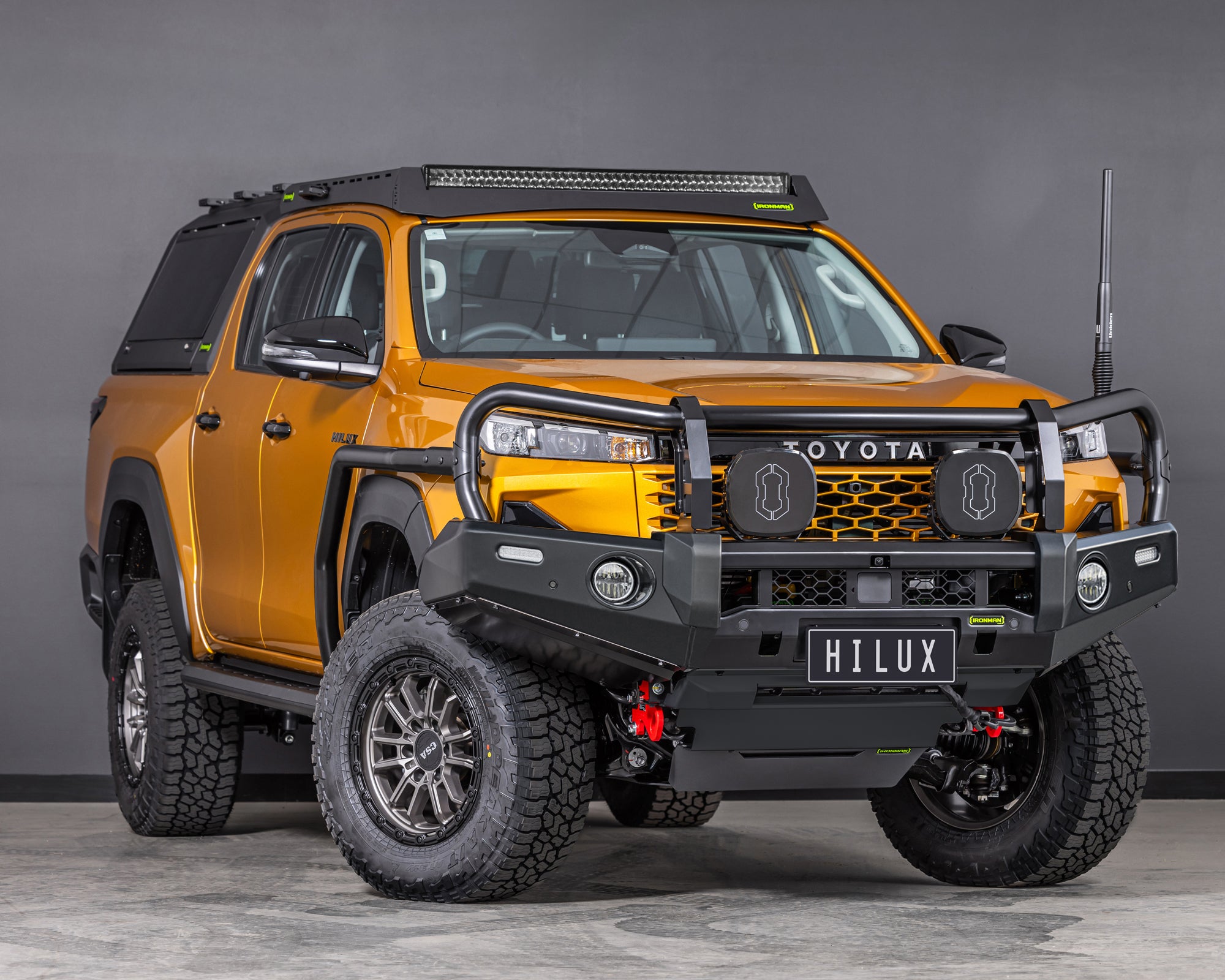 toyota-hilux-n90-2026-sunglow-orange-with-ironman-4x4-deluxe-bull-bar-front-thee-quarter-angle